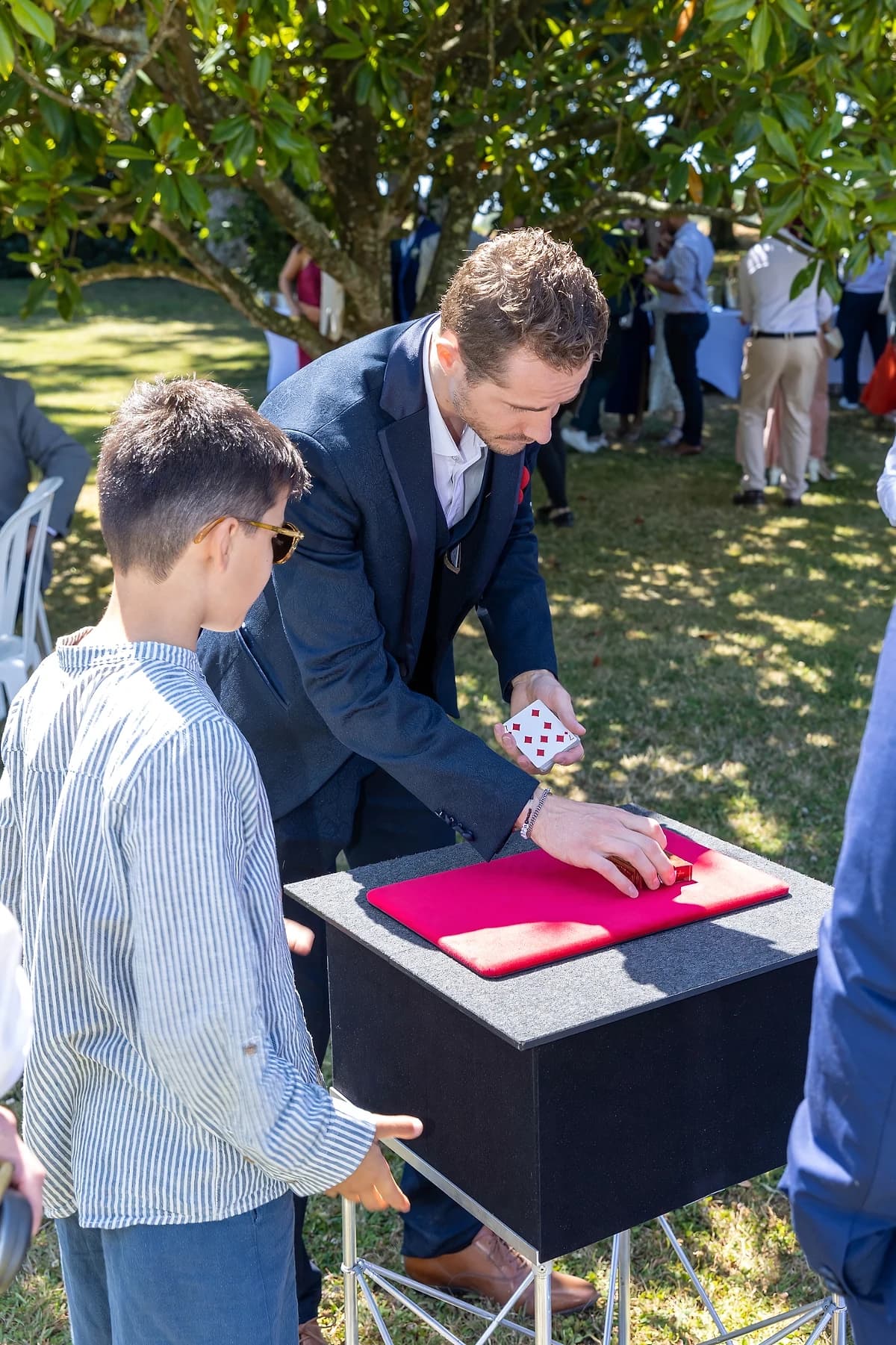 Un jeune invité ne quitte pas des yeux les mains du magicien
